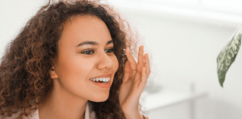 A young woman putting a contact lens in her eye